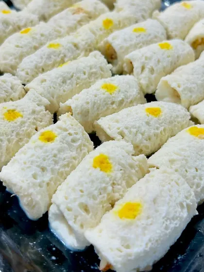 A tray of my Chena Rolls, a classic Bengali sweet. These soft, melt in your mouth rolls are made from fresh cheese and filled with a sweet mawa mixture, offering a delicate and delicious treat.
