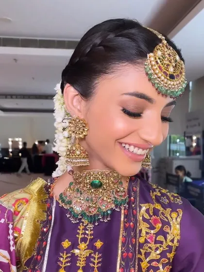 A happy and radiant bride. The makeup is fresh and natural, with a focus on a beautiful smile and glowing skin. This is perfect for a Mehendi or Haldi ceremony.