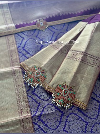 A close-up of the sleeve detail on a purple blouse, featuring peacock motifs made from kemp stones.