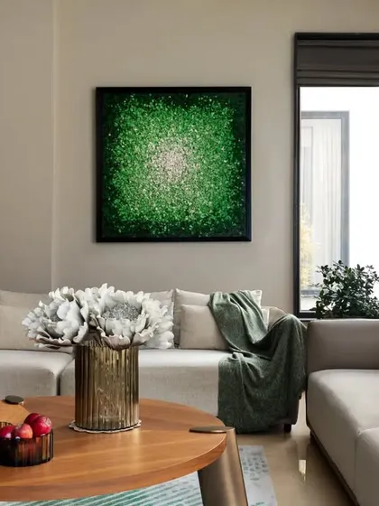 The living room at the KKB Residence is a calm oasis, with a neutral sofa, warm wood coffee table, and a vibrant green piece of art that brings a burst of energy to the space.