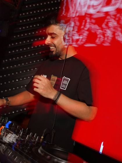 In the zone at Ginza, another one of Bangalore's top spots. The intense red backdrop and my focus on the Pioneer decks show the concentration it takes to keep the energy high.