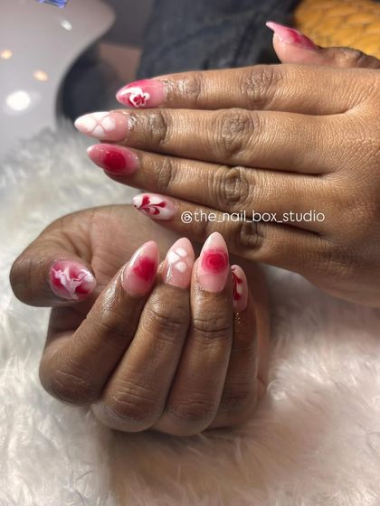 Another angle of the red and white floral acrylic extension set. The detail on each nail is unique, yet they all come together to create a cohesive and beautiful design.