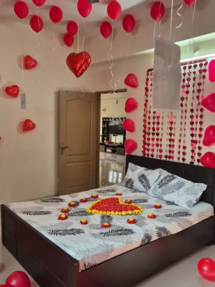 A classic romantic room surprise, perfect for anniversaries or just because. The decoration includes a heart made of flower petals on the bed, with red heart-shaped foil and latex balloons filling the room to create a warm, loving atmosphere.