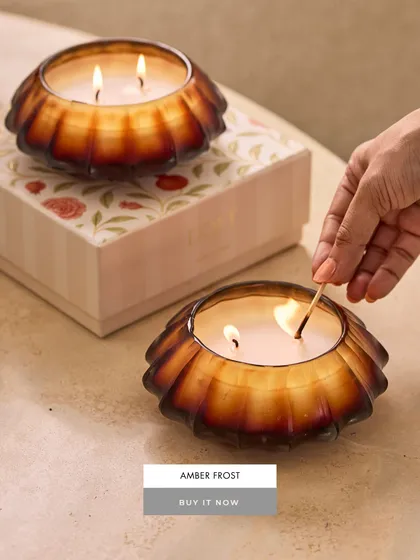 The Amber Frost candle, with its unique scalloped shape and warm amber-colored glass, is a beautiful object even before it's lit. The dual wicks provide a strong, even burn, filling your room with a cozy fragrance.