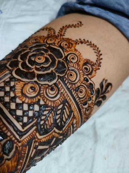 A close-up of a beautiful bridal henna design, showing the intricate details of the floral and geometric patterns.
