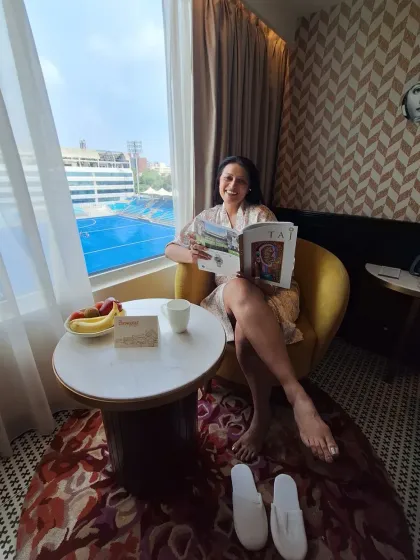 Enjoying a quiet morning with a magazine and coffee at The Connaught, New Delhi. This image captures the serene and comfortable experience of a city-based luxury staycation.