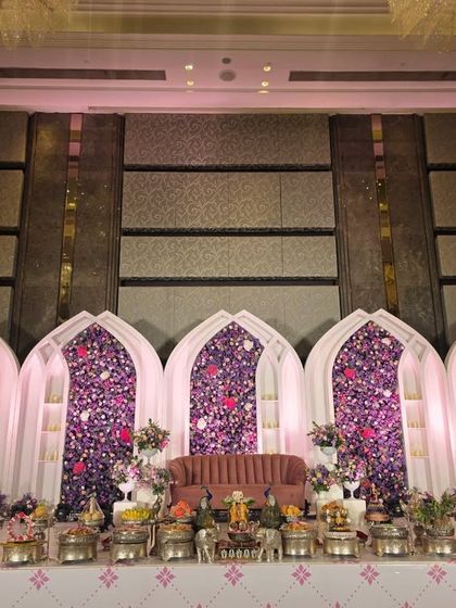 Another wide shot of the purple floral arch stage, showing the intricate details of the offering table.