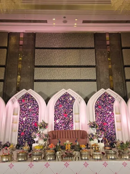Another wide shot of the purple floral arch stage, showing the intricate details of the offering table.