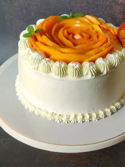 A smaller version of my mango rose cake, perfect for intimate celebrations. It has the same beautiful mango topping and is finished with a delicate piped buttercream border and a whimsical butterfly accent.
