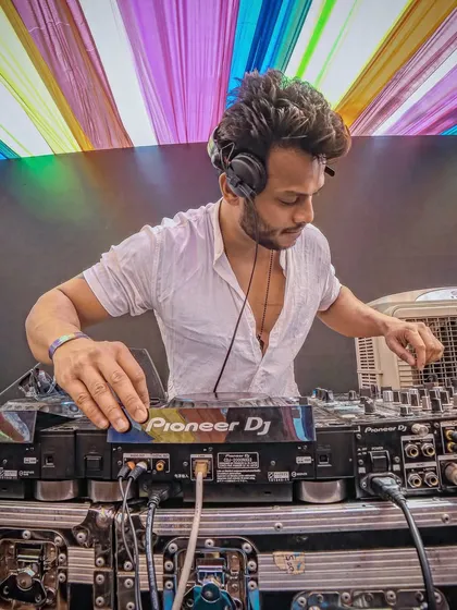 Focused on the mix at my Pioneer DJ setup during a colorful Holi event. Even in the middle of a wild party, my attention is on delivering the perfect track selection.
