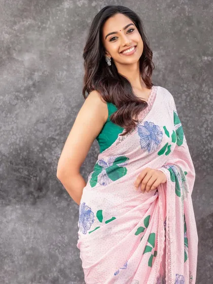 Another shot from the floral saree series, showing a slightly different pose. The styling is consistent, focusing on a happy, approachable aesthetic for contemporary Indian fashion.