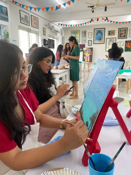 A group of participants engrossed in a canvas painting session, each working on their own masterpiece. The studio buzzes with creative energy during these workshops.
