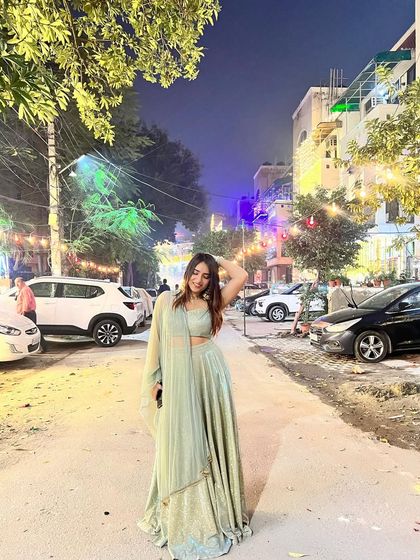 A confident pose in the street, showing off the full lehenga. This blends traditional wear with a modern, urban setting.