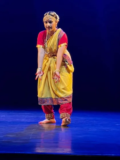 A moment of pure expression from a Bharatnatyam performance. Our classes focus deeply on `abhinaya` (facial expressions) and `mudras` (hand gestures) to tell stories with grace and devotion.