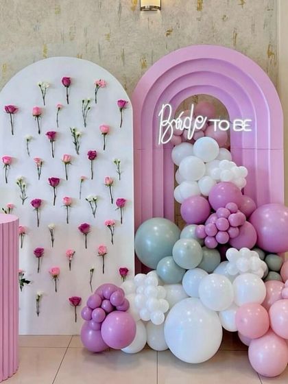 Bridal showers should be as beautiful as the bride-to-be. This elegant setup features a custom floral wall backdrop, a neon sign, and a pastel balloon garland, creating a soft and romantic atmosphere for the celebration.
