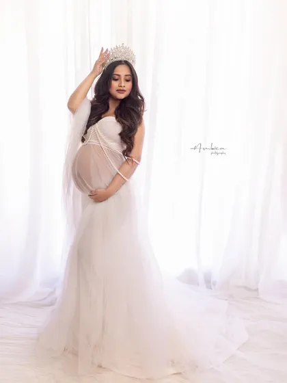 Slaying it like a queen. This portrait in a sheer white gown, complete with a crown and pearl details, is the epitome of regal elegance. Her pose is full of grace and confidence.