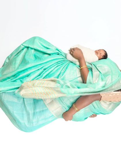 A creative reflection shot showing a mother holding her newborn. This artistic photo symbolizes the beautiful transition from pregnancy to motherhood, all done on a clean white background.