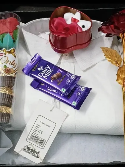 A sweet and simple gift box containing a white shirt, Ferrero Rocher chocolates, and decorative roses, perfect for any celebration.