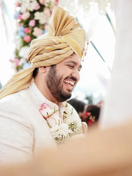 A candid shot of the groom's joyful laughter during the wedding ceremony. These genuine expressions are what make a wedding album come alive.