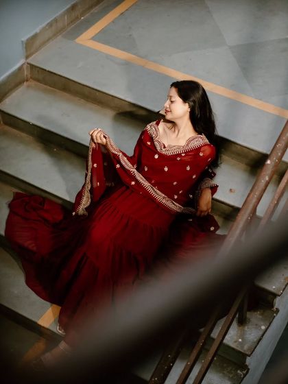 This shot, taken through the stair railing, creates a sense of looking in on a private, quiet moment. It adds an artistic, framed element to the portrait.