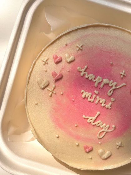 A minimalist pink airbrushed bento cake with tiny hearts and sparkles. This design is simple, sweet, and perfect for celebrating your 'mimi day'.