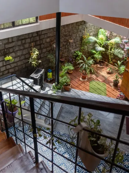 I love bringing the outdoors inside. This central courtyard at the Gifty Residence acts as the green heart of the home, visible from multiple levels. The combination of rugged stone walls, vibrant plants, and decorative floor tiles creates a dynamic yet peaceful core that fills the home with life and natural light.