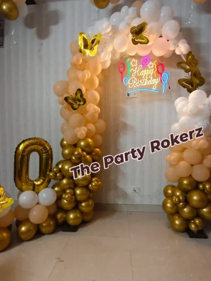 A chic and elegant 10th birthday decoration for twins. I used a gold, white, and peach color scheme with a simple balloon arch, butterfly accents, and a "Happy Birthday" neon sign.