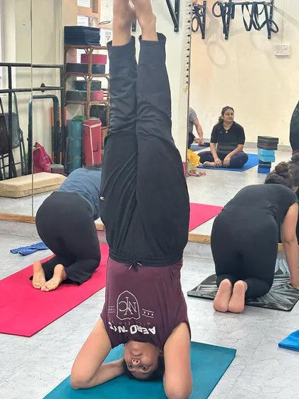 A student holds a steady Sirsasana (Headstand), a foundational inversion that calms the mind and strengthens the entire body.