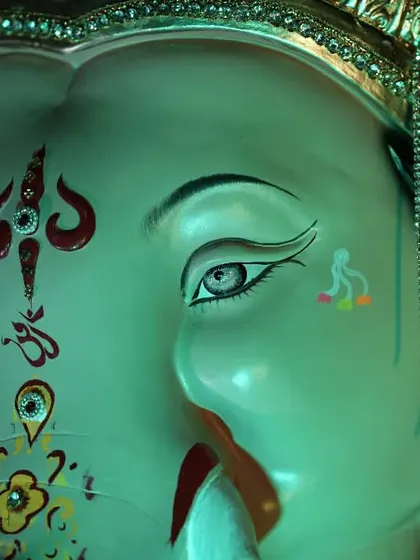 A close-up on the expressive eyes and detailed facial paintings of the Palmbeach Cha Vighnaharta idol.
