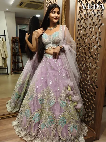 The mirror reflection shows off the beautiful back and the playful tassels on this lavender lehenga.