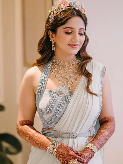 A beautiful solo portrait of the bride, showcasing her unique, contemporary saree and floral tiara.