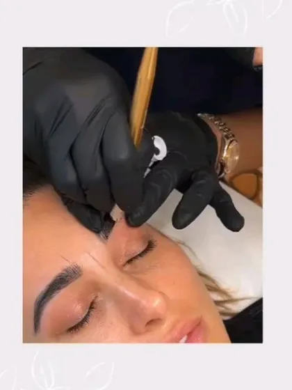 An intimate look at the nanoblading procedure. The artist's gloved hands carefully apply pigment, illustrating the steady, expert touch required for creating flawless, natural-looking brows for a relaxed client.