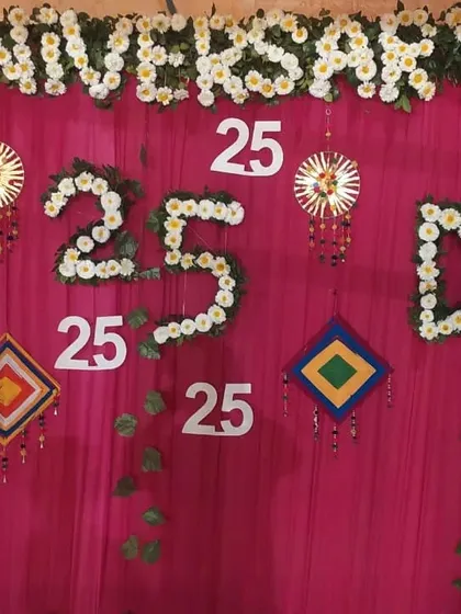 A custom backdrop I created for a 25th anniversary party. I used white flowers to spell out 'ANNIVERSARY' and create the number '25' against a bright pink curtain.