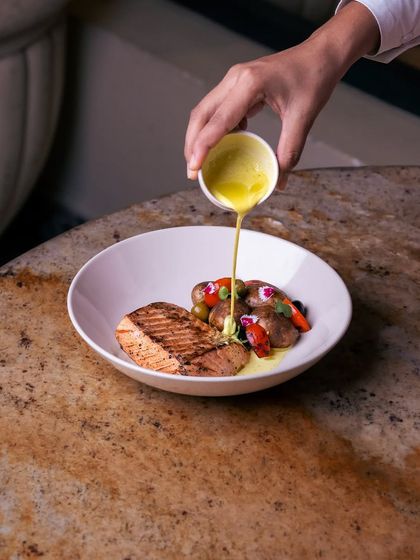 A recreation of a dish from Upali's in Colombo. Dutch oven-baked salmon is plated over a delicately spiced Ceylon coconut curry with roasted baby potatoes.