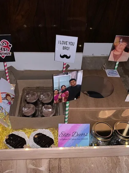 I love adding personal memories to my hampers. This unique Rakhi gift for a brother features custom stands with your favorite photos and fun messages like 'World's Best Brother', alongside shot glasses and homemade chocolates.