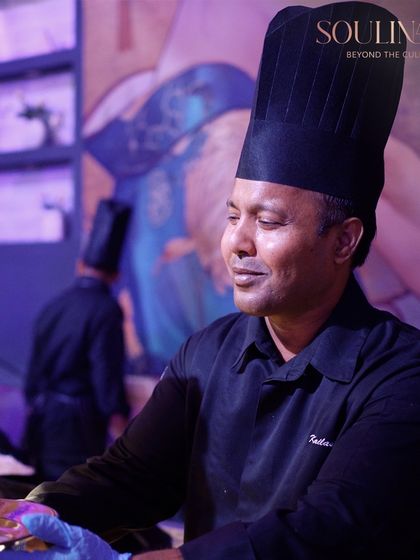 A portrait of one of our talented chefs, smiling as he serves guests. His dedication and passion are representative of the entire Soulinaire team.