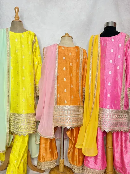 The Pimmo kurta set is a festive favorite. Available in bright yellow, orange, and pink, this sharara-style set is made from shimmering fabric with intricate gota patti work.