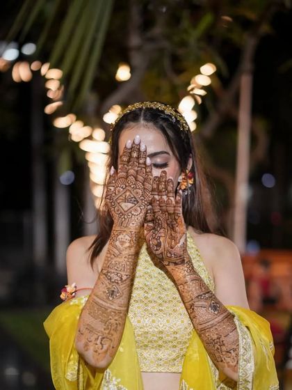 "Mehndi hai rachne wali..." A classic pose for a classic bride. Her full-arm mehendi looks absolutely stunning as she peeks through her hands.