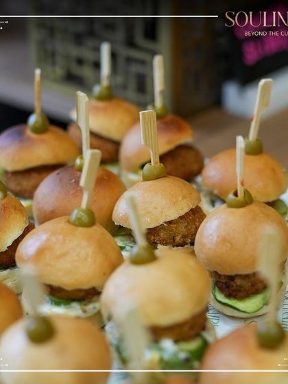 A close-up of delicious mini-burgers, or sliders, prepared for a corporate expo. Our menus include a variety of crowd-pleasing options suitable for any event format.