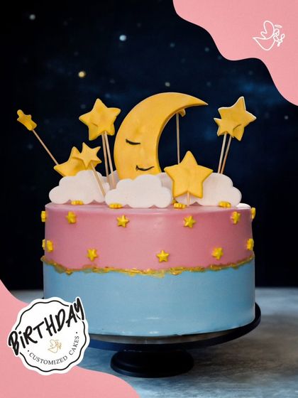 A dreamy night sky cake, featuring a sleeping moon, fluffy clouds, and golden stars. This whimsical design is perfect for celebrating a little dreamer's birthday.