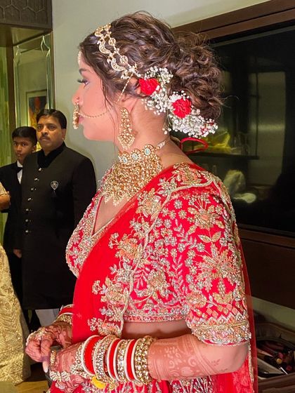 A side view of the messy bun, adorned with small red and white flowers.