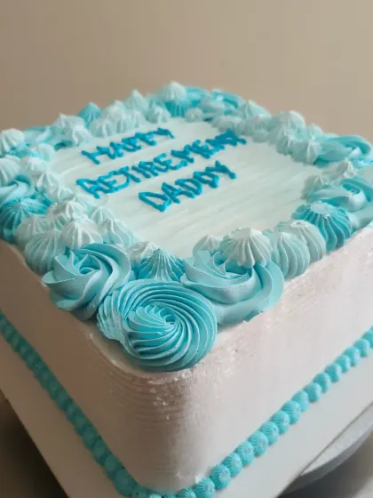 Another view of the square retirement cake, showing the piped border and rosette details.