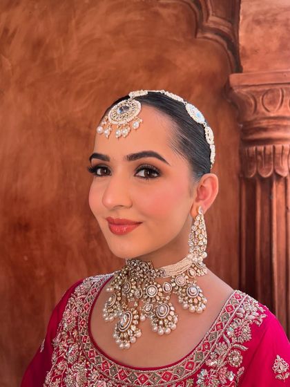 Bridal glam in its full glory. This look features a sleek hairstyle and clean, glowing makeup with a focus on flawless skin and defined brows.
