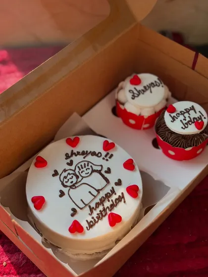 A sweet birthday gift for Shreyas, this set includes a bento cake with a cute cartoon couple and two personalized cupcakes. The red heart details tie the whole theme together perfectly.