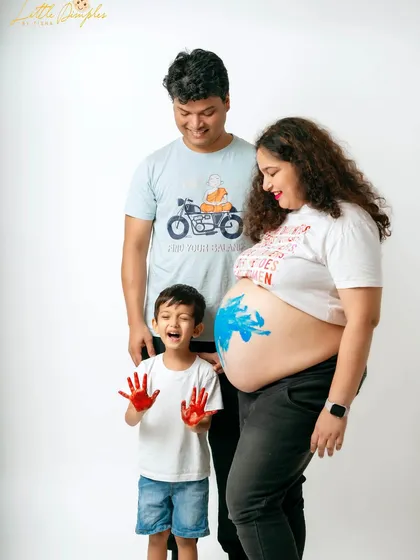 The older brother proudly shows off his paint-covered hands in this creative maternity announcement. It's a wonderful way to make him feel part of the excitement.