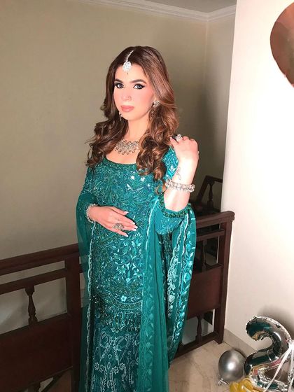 A full shot of the client in a beautiful green outfit, her hair styled in elegant curls. The hairstyle adds a touch of sophistication to her festive look.