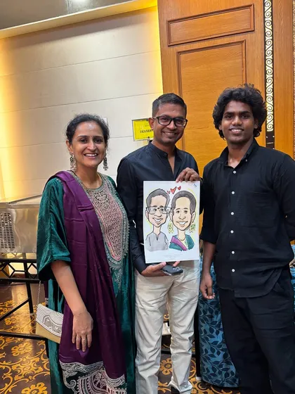 A beautiful couple portrait drawn live at an event. I am standing with the happy clients who now have a unique piece of art to remember the occasion.