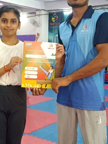 A student receives her "JUMP" program certificate, marking her progress to a new level.