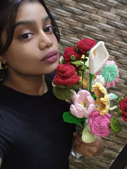 A selfie with a huge armful of my crochet flowers! This shows the wide variety of flowers I can make, from roses and lilies to tulips and more.