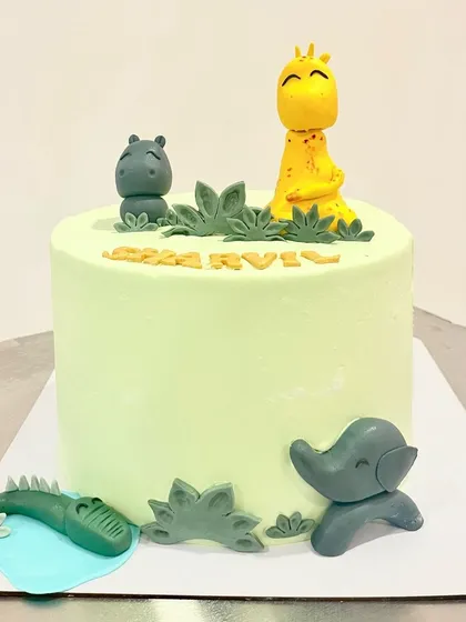 A cute and simple jungle theme cake. This design uses minimal fondant for the animal figurines like the giraffe, hippo, and elephant, keeping the focus on the delicious light green buttercream.